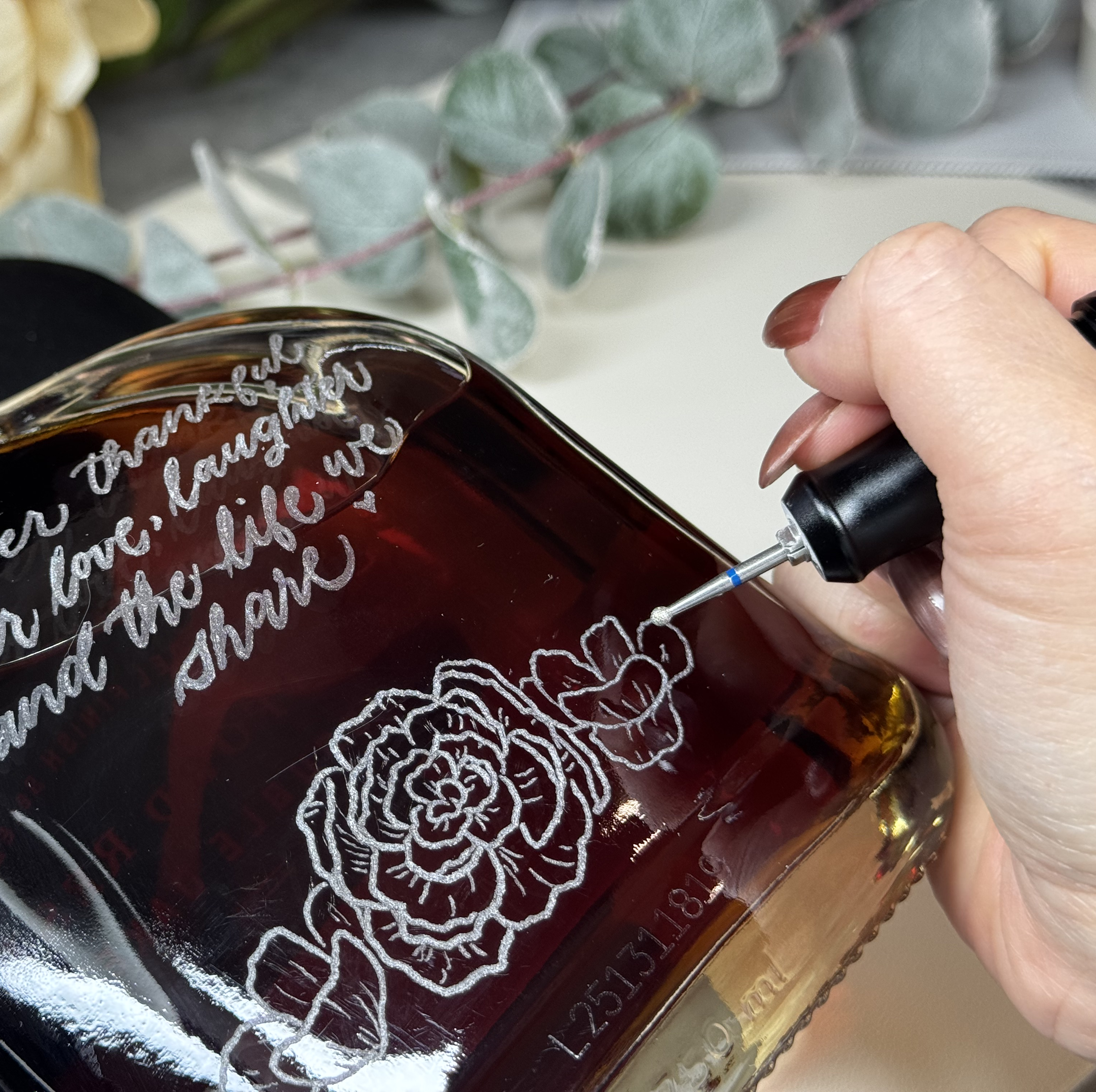 Lyna Truong, calligraphy artist engraving bottle